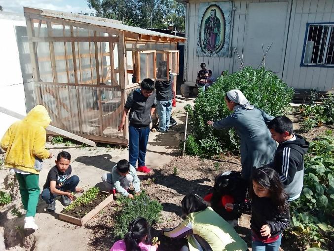 Hermana Esperanza and children working in the garden